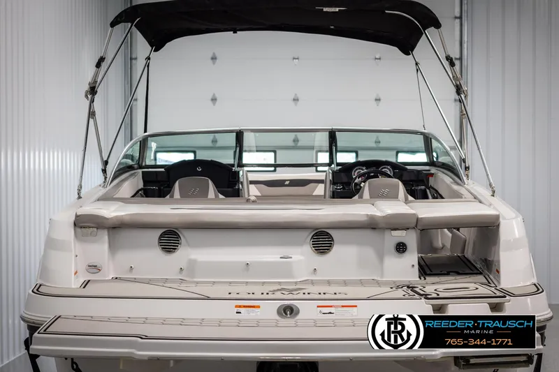 Slide: The Image of 2019 Four Winns HD200 boat, rear view, in a storage facility with canopy. - 7