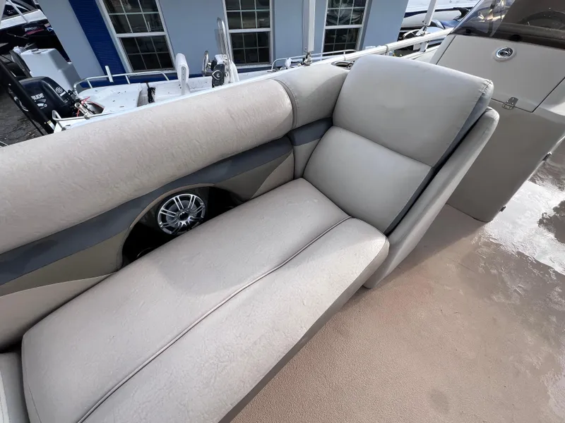 Slide: The Image of 2013 Harris FloteBote Sunliner 220 boat interior with beige seating and speaker. - 17