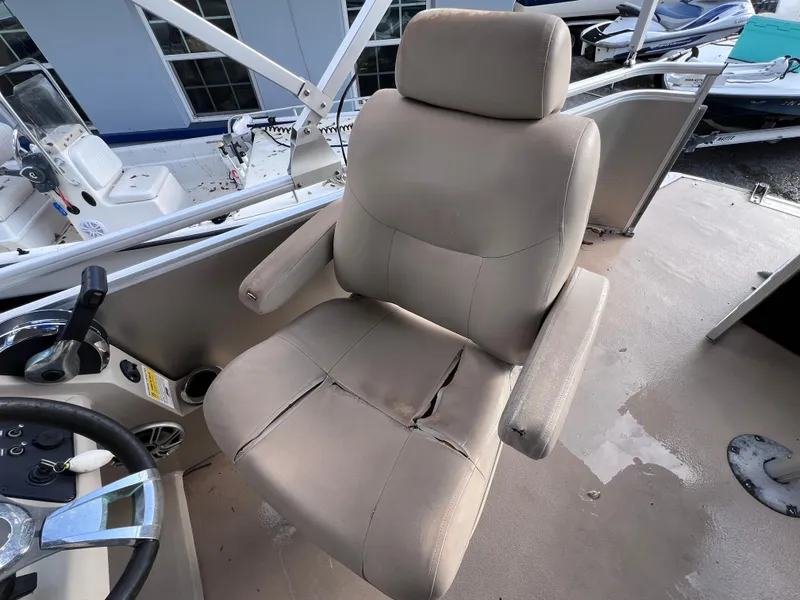 Slide: The Image of 2013 Harris FloteBote Sunliner 220 captain's chair with visible wear and tear. - 18