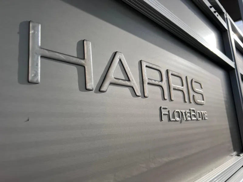 Slide: The Image of 2013 Harris FloteBote Sunliner 220 logo on boat exterior. - 2