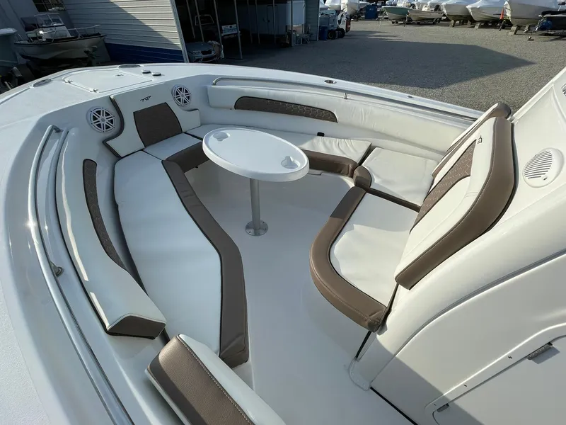 Slide: The Image of 2025 Tidewater 232 SS boat interior with cushioned seating and round table. - 12