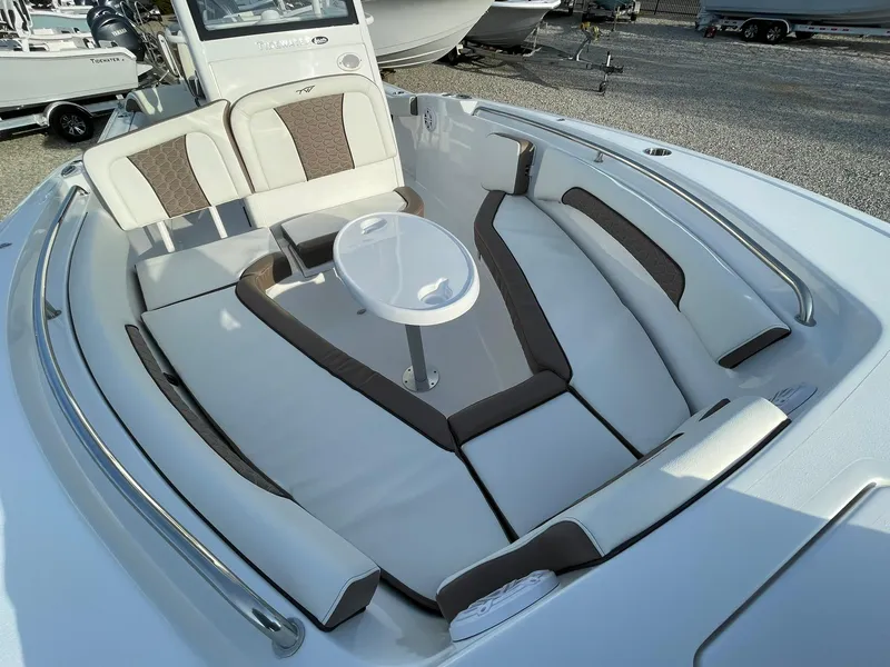 Slide: The Image of 2025 Tidewater 232 SS boat interior with cushioned seating and a central table. - 13