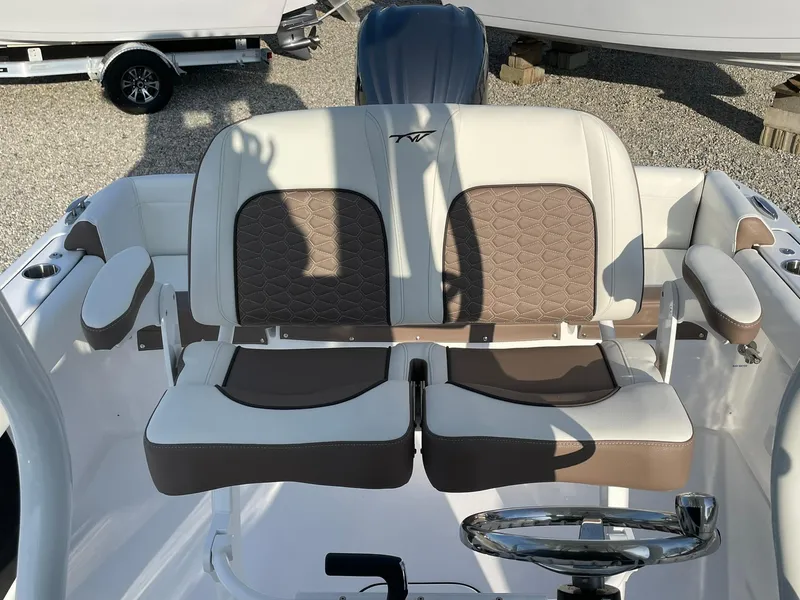 Slide: The Image of 2025 Tidewater 232 SS boat interior with cushioned seating and modern design. - 35