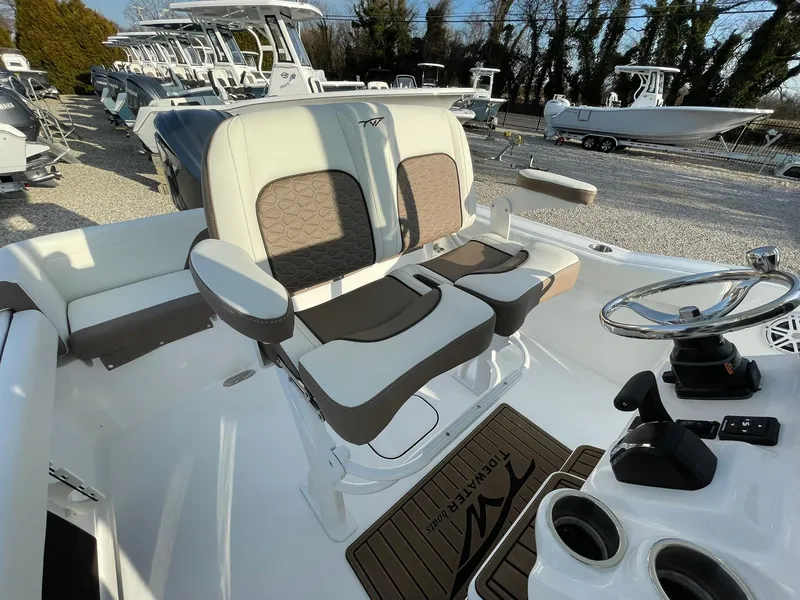 Slide: The Image of 2025 Tidewater 232 SS boat interior with dual seats and steering wheel, displayed outdoors. - 37