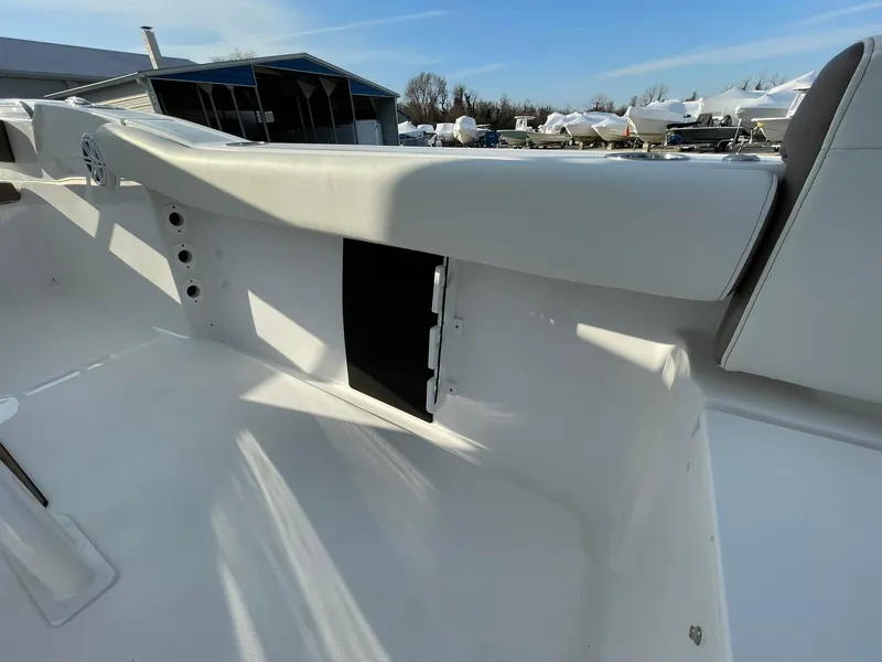 Slide: The Image of 2025 Tidewater 232 SS boat interior with white seating and storage compartment. - 44