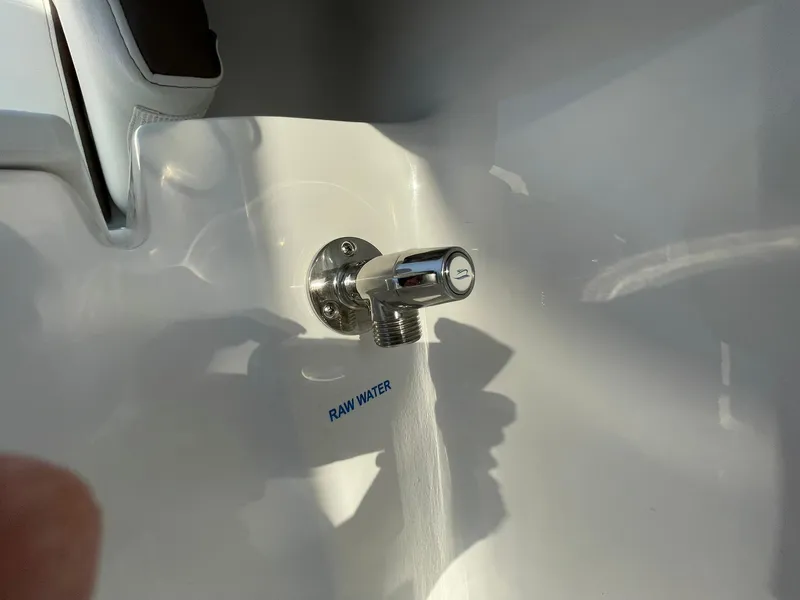 Slide: The Image of 2025 Tidewater 232 SS boat interior with storage compartment, docked under clear blue sky. - 45