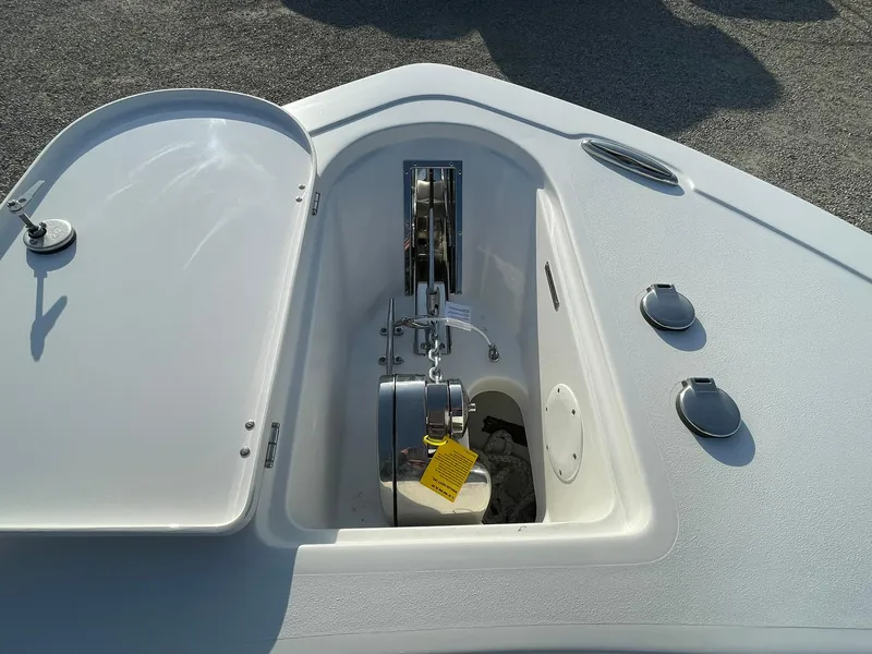 Slide: The Image of 2025 Tidewater 232 SS boat anchor compartment with open hatch and visible anchor mechanism. - 6