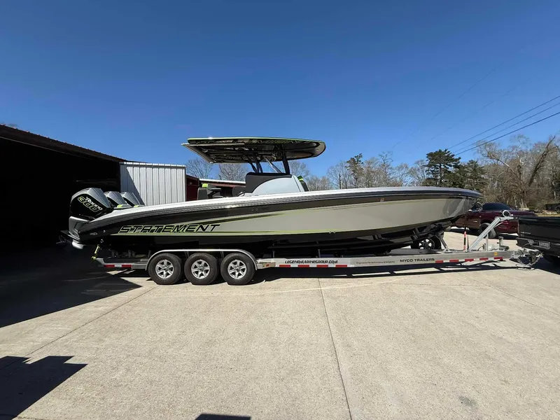 Slide: The Image of 2024 Statement 350 Open boat on trailer, parked outdoors under clear blue sky. - 18