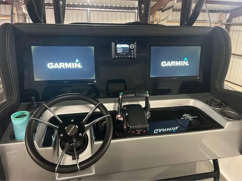 Slide: The Image of 2024 Statement 350 Open boat dashboard with Garmin displays and steering wheel. - 22