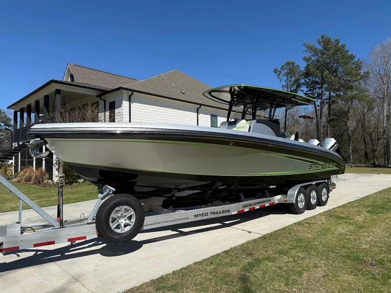 Slide: The Image of 2024 Statement 350 Open boat on trailer, parked in residential driveway, sunny day. - 5