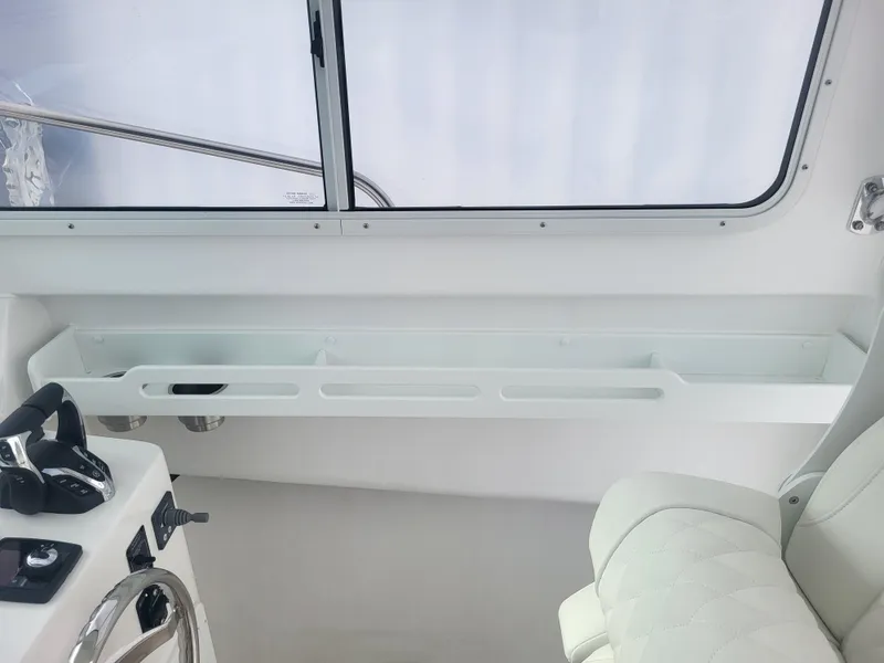 Slide: The Image of 2025 Steiger Craft 28 Fisherman interior, featuring helm controls and seating. - 24