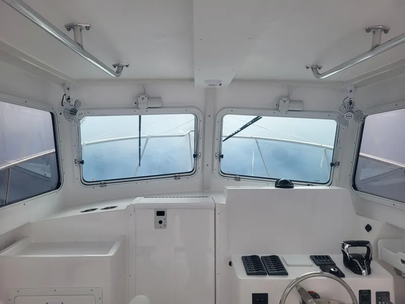 Slide: The Image of Interior view of 2025 Steiger Craft 28 Fisherman boat cabin with windows and controls. - 26