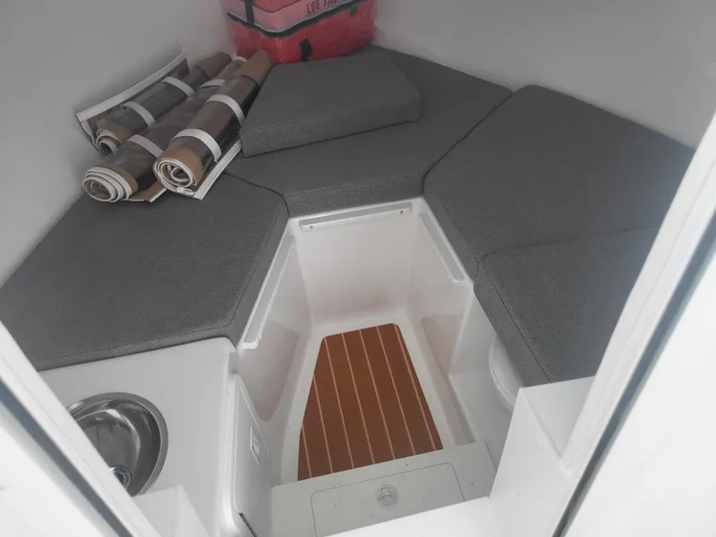 Slide: The Image of 2025 Steiger Craft 28 Fisherman cabin interior with gray cushions and wooden flooring. - 29