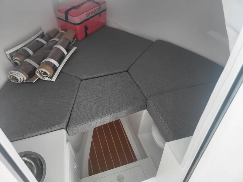 Slide: The Image of 2025 Steiger Craft 28 Fisherman cabin interior with gray cushions and storage. - 31