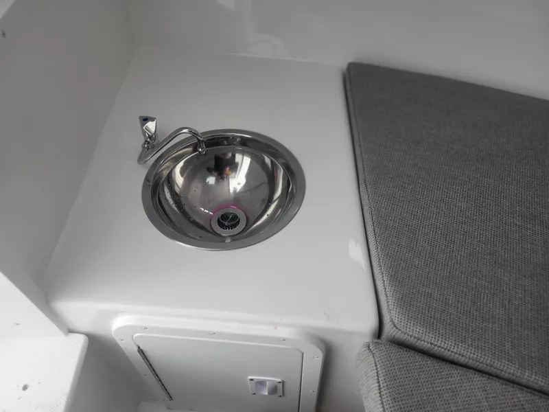 Slide: The Image of 2025 Steiger Craft 28 Fisherman interior with sink and cushioned seating. - 32