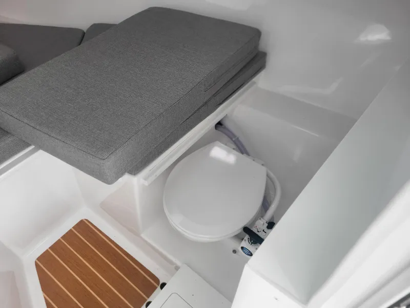 Slide: The Image of 2025 Steiger Craft 28 Fisherman interior with cushioned seating and marine toilet. - 33