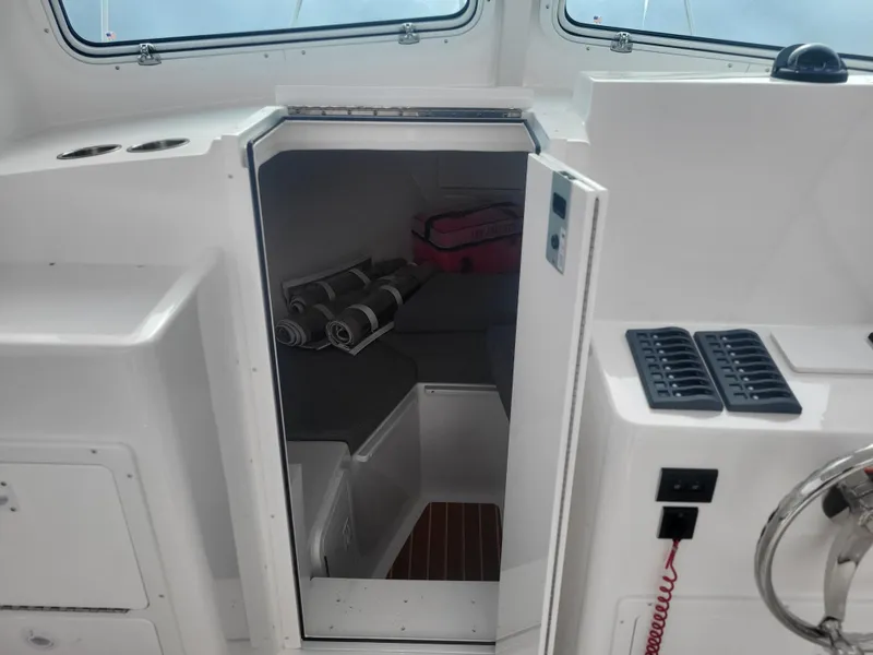 Slide: The Image of 2025 Steiger Craft 28 Fisherman cabin interior with rolled towels and storage. - 34