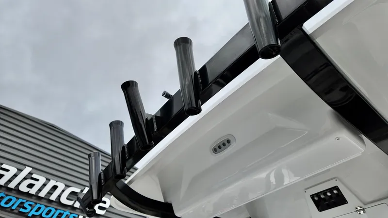 Slide: The Image of 2025 Sea Fox 228 Commander boat with rod holders, viewed from below against a cloudy sky. - 21