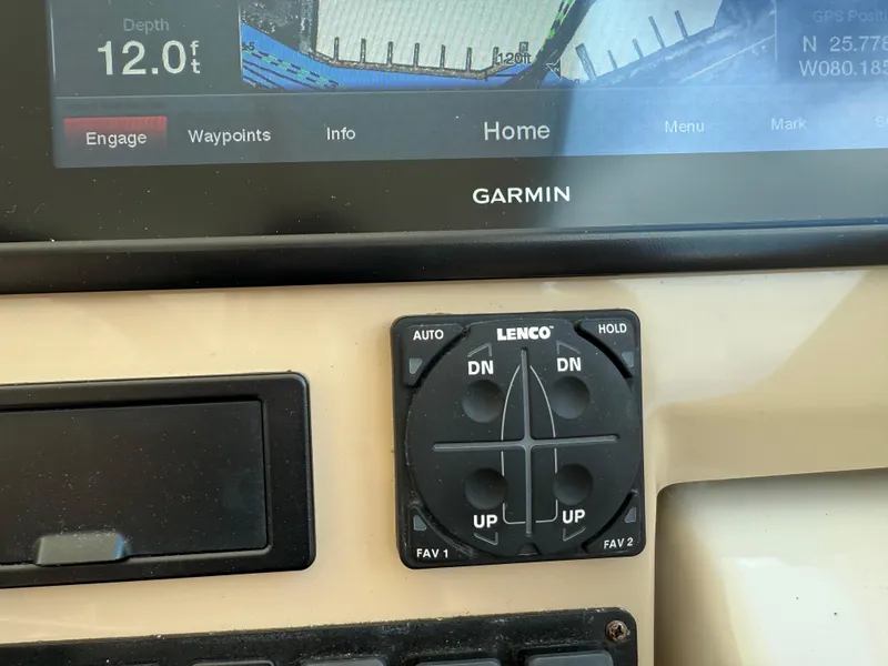 Slide: The Image of Control panel of a 2014 Tiara Yachts 4500 Sovran with labeled switches and Garmin device. - 27