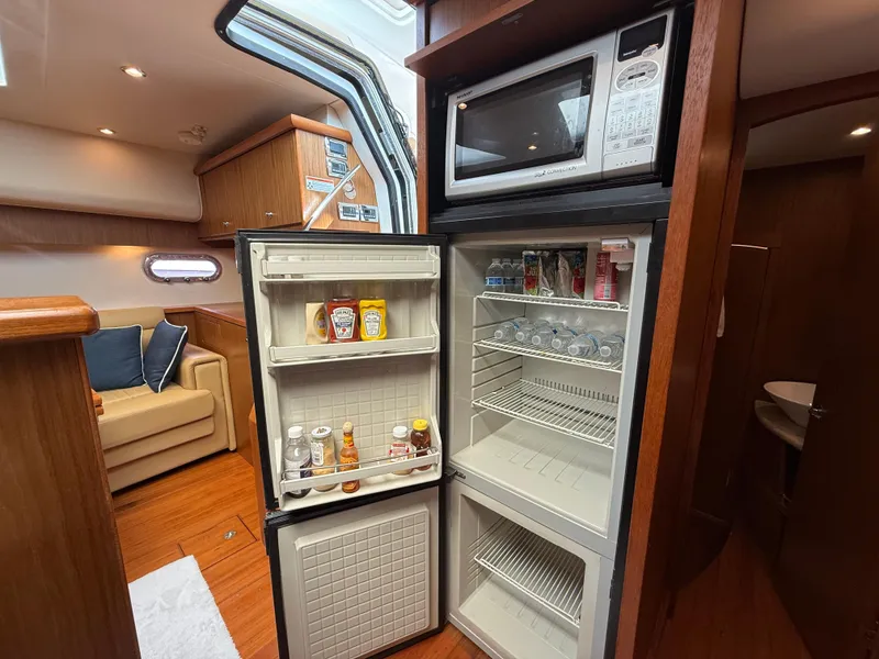 Slide: The Image of 2014 Tiara Yachts 4500 Sovran interior kitchen with wood cabinetry and modern appliances. - 49