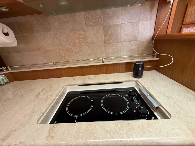 Slide: The Image of 2014 Tiara Yachts 4500 Sovran kitchen with wooden cabinets and marble countertop. - 51