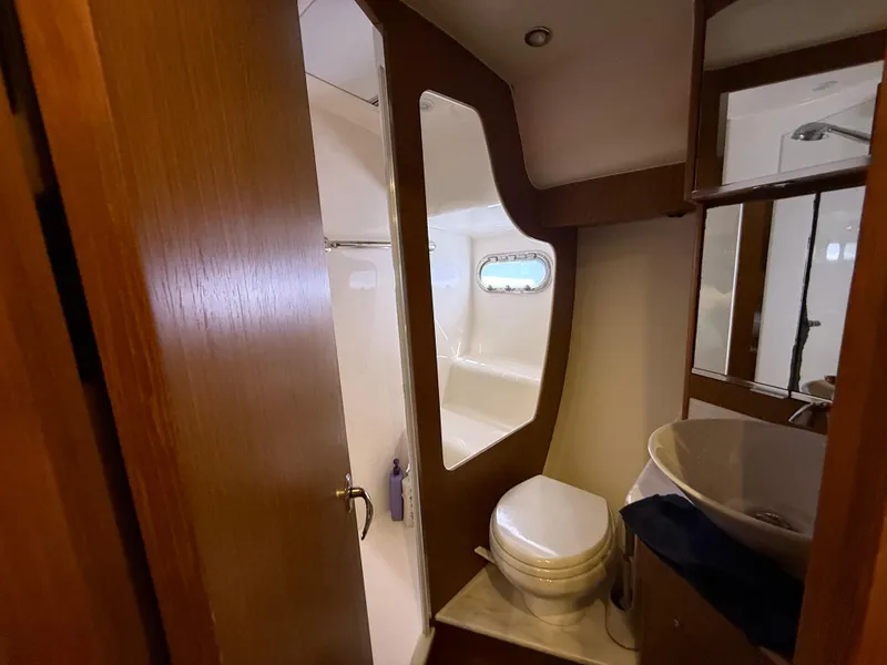 Slide: The Image of Storage closet in 2014 Tiara Yachts 4500 Sovran, featuring shelves, hangers, and a fire extinguisher. - 61