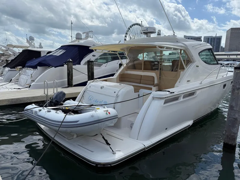 Slide: The Image of 2014 Tiara Yachts 4500 Sovran docked with inflatable boat, city skyline in background. - 83