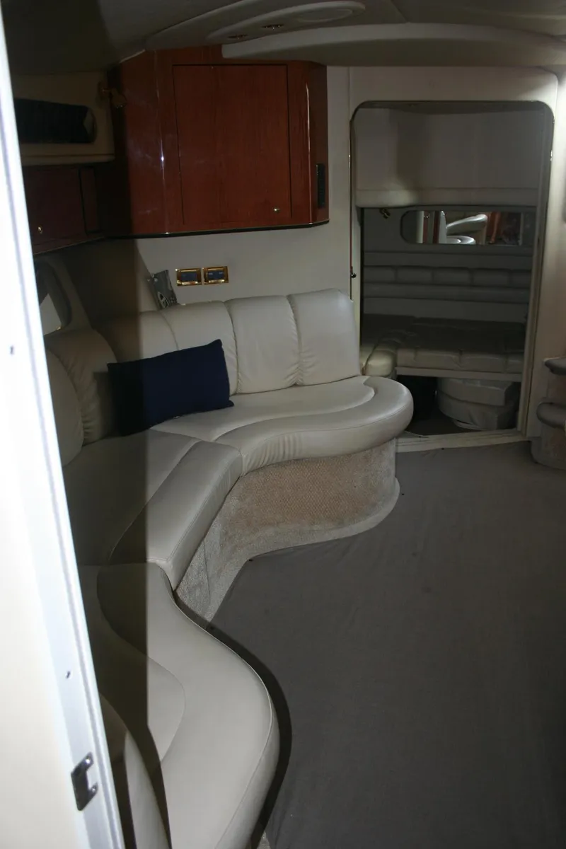 Slide: The Image of 1999 Sea Ray 400 Sundancer interior with cream leather seating and wooden cabinetry. - 12