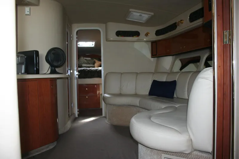 Slide: The Image of 1999 Sea Ray 400 Sundancer interior with cream leather seating and wooden cabinetry. - 14
