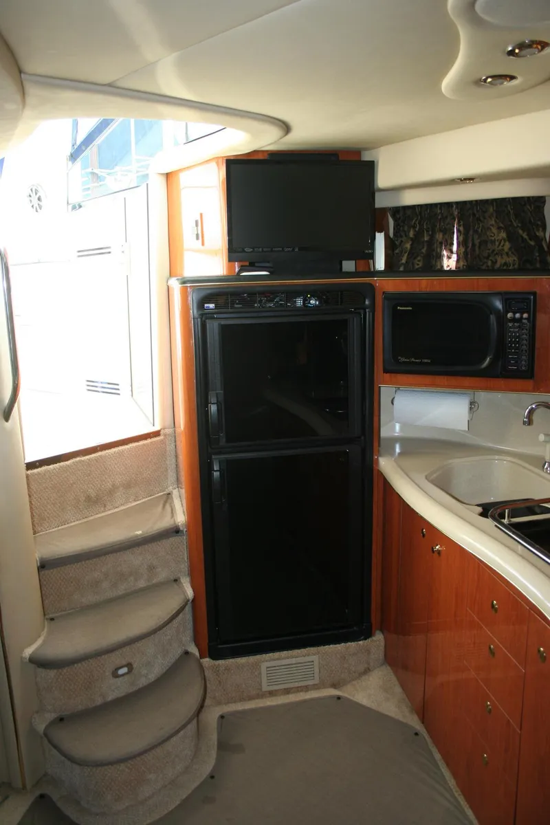 Slide: The Image of 1999 Sea Ray 400 Sundancer bathroom with sink, toilet, and storage cabinet. - 18