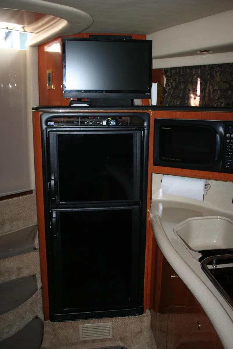 Slide: The Image of 1999 Sea Ray 400 Sundancer cabin interior with beige seating and pillows. - 19
