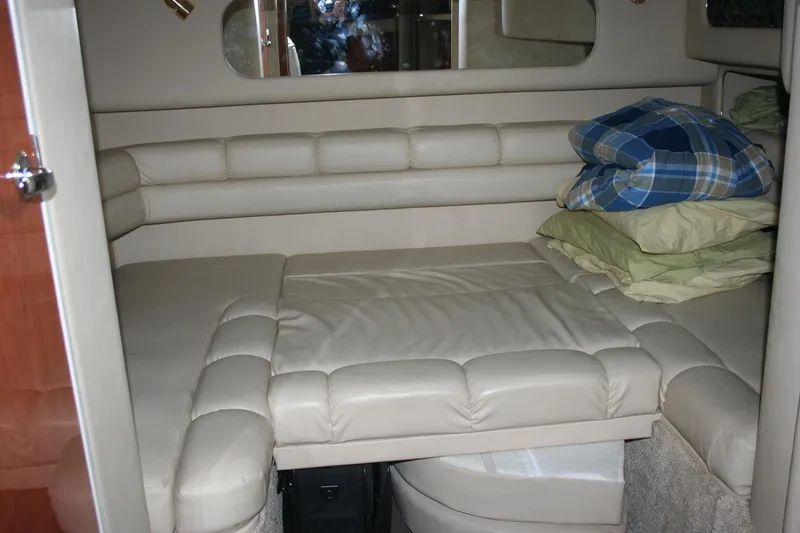 Slide: The Image of Interior of 1999 Sea Ray 400 Sundancer yacht with curved leather seating and wooden cabinetry. - 21