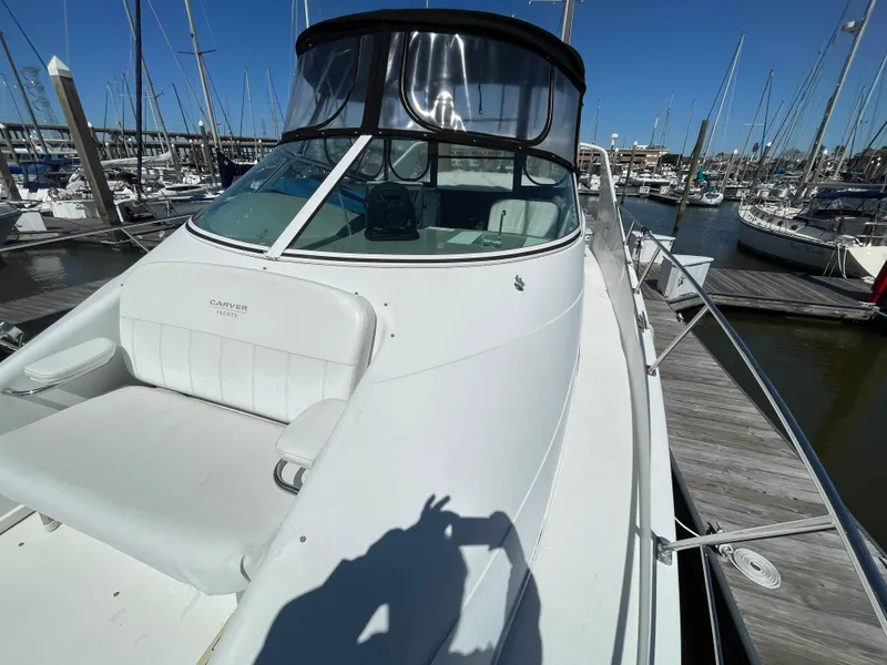 Slide: The Image of 2000 Carver 350 Mariner yacht docked at marina, featuring spacious deck and sleek design. - 10