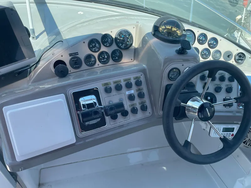 Slide: The Image of Control panel of a 2000 Carver 350 Mariner boat with steering wheel and gauges. - 14