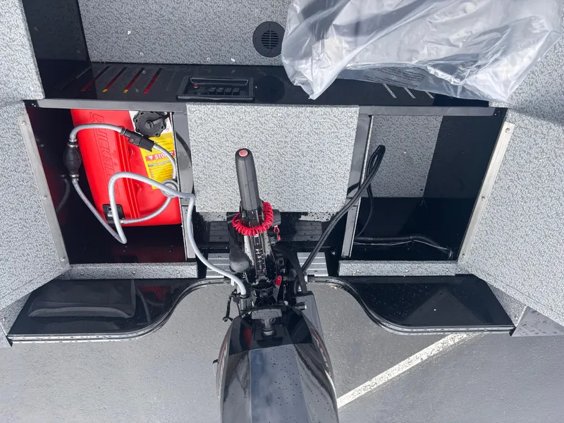 Slide: The Image of 2025 Crestliner 1650 Discovery Tiller boat interior with storage compartments and motor. - 5