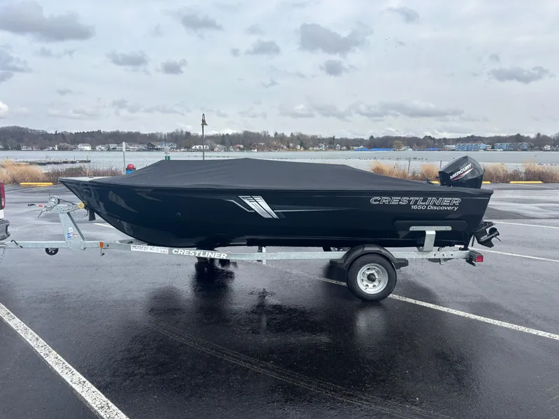 Slide: The Image of 2025 Crestliner 1650 Discovery Tiller boat on trailer, parked in wet lot. - 6