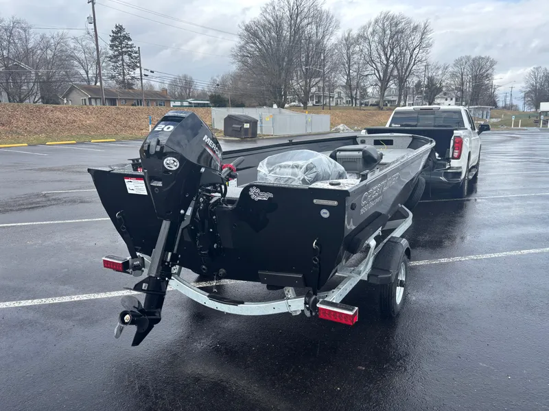 Slide: The Image of 2025 Crestliner 1650 Discovery Tiller boat on trailer, parked in a wet parking lot. - 8