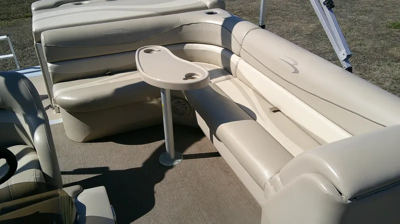 Slide: The Image of 2011 Bennington 2571 GLi boat interior with beige seating and small table. - 9