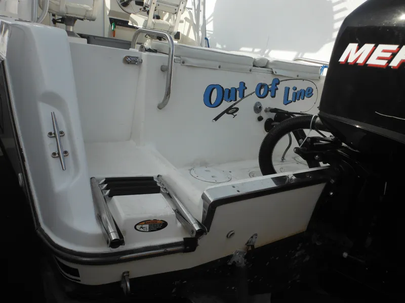 Slide: The Image of 1999 Robalo 2440 Walkaround boat with "Out of Line" name and Mercury engine. - 12