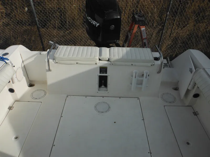 Slide: The Image of 1999 Robalo 2440 Walkaround boat deck with seating and Mercury engine. - 14