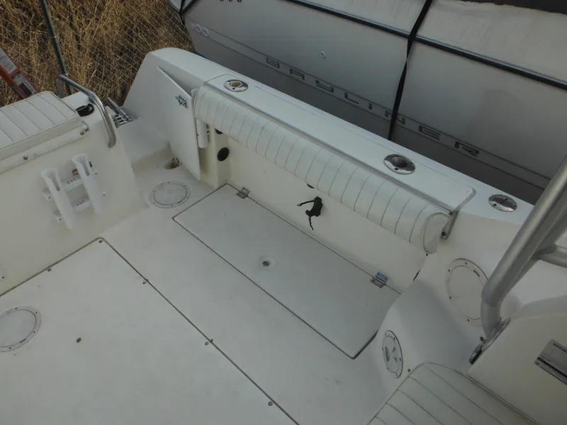 Slide: The Image of 1999 Robalo 2440 Walkaround boat deck with seating and storage compartments. - 16