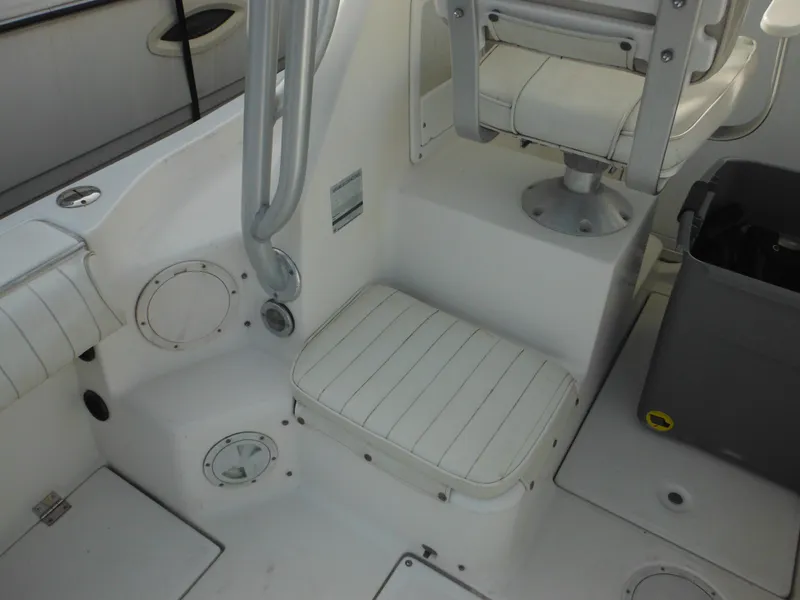 Slide: The Image of 1999 Robalo 2440 Walkaround boat interior with white seating and storage area. - 17
