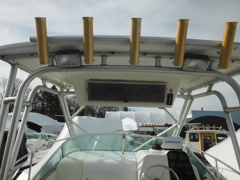 Slide: The Image of 1999 Robalo 2440 Walkaround boat cockpit with rod holders and navigation equipment. - 19