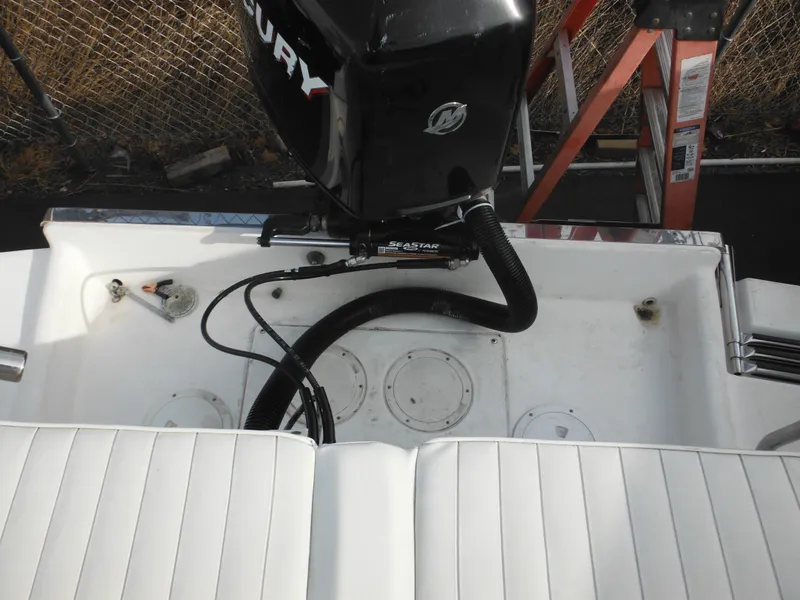 Slide: The Image of 1999 Robalo 2440 Walkaround boat with Mercury outboard engine and white seating. - 23
