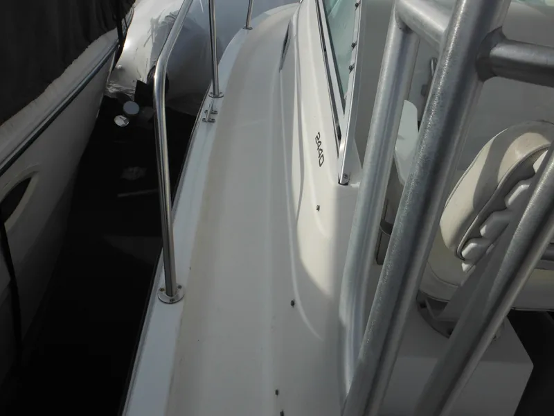 Slide: The Image of 1999 Robalo 2440 Walkaround boat deck with railing and seating. - 24