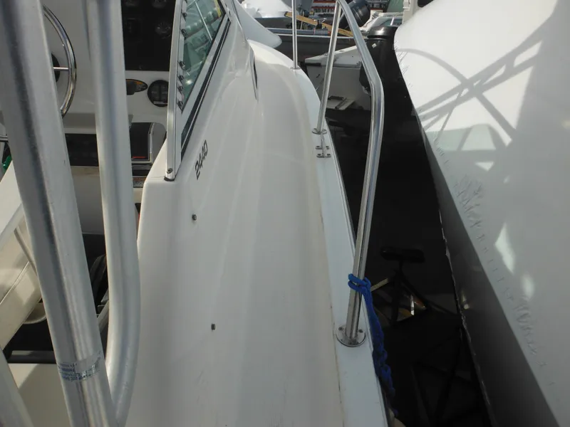 Slide: The Image of 1999 Robalo 2440 Walkaround boat deck with railing and cockpit view. - 26