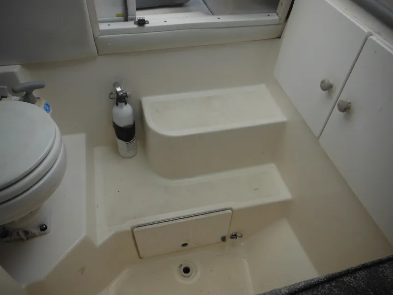 Slide: The Image of Interior of 1999 Robalo 2440 Walkaround boat with toilet and storage compartments. - 30