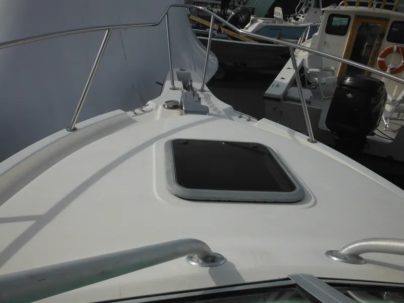 Slide: The Image of 1999 Robalo 2440 Walkaround boat deck with hatch and railing. - 34