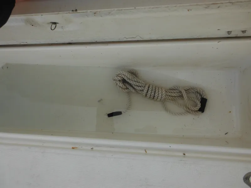 Slide: The Image of 1999 Robalo 2440 Walkaround boat compartment with coiled rope inside. - 36