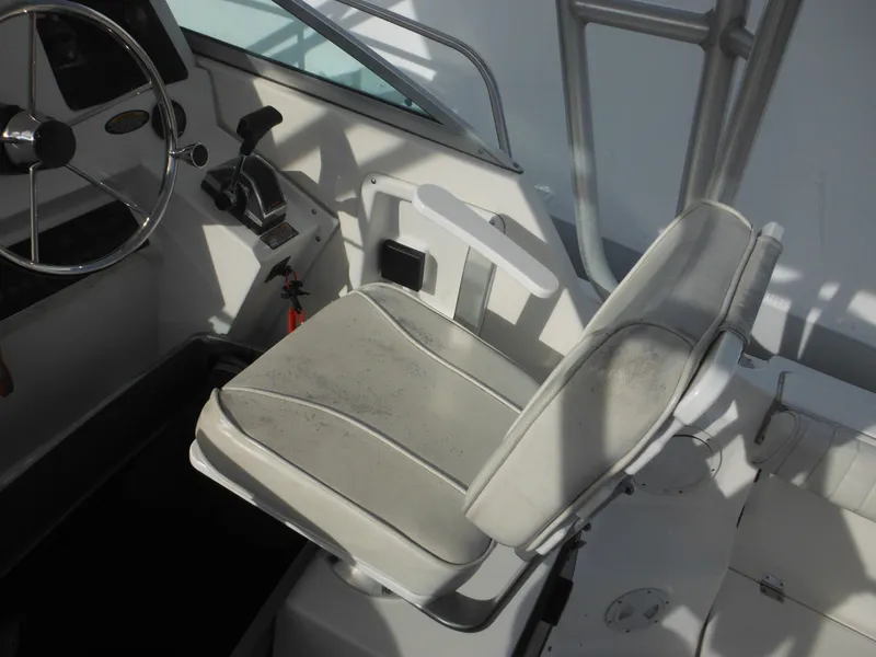 Slide: The Image of 1999 Robalo 2440 Walkaround boat cockpit with steering wheel and seat. - 37